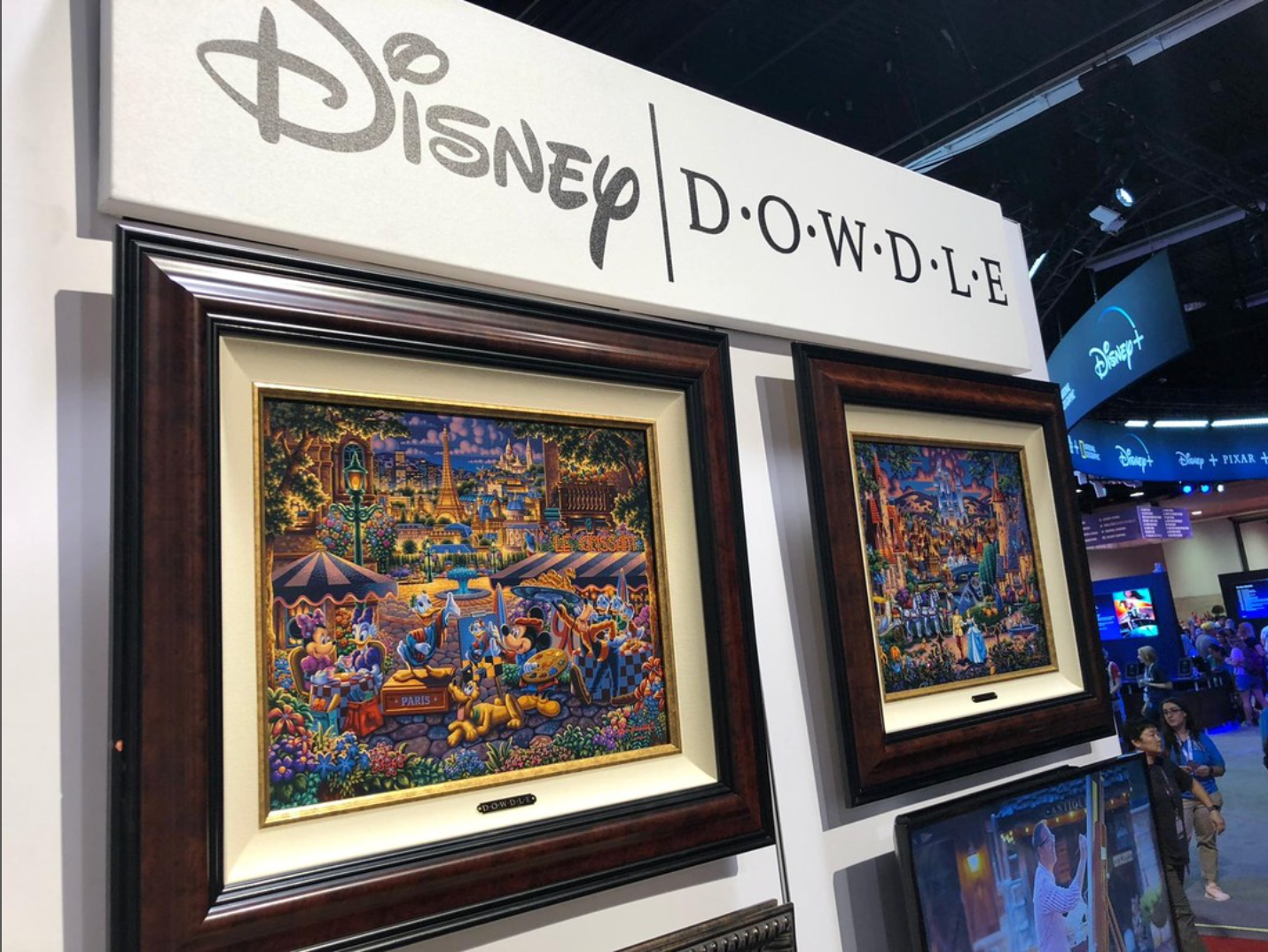 Framed Disney and Dowdle Studios artwork displayed at an art expo – Art Brand Studios Wholesale Partner Application