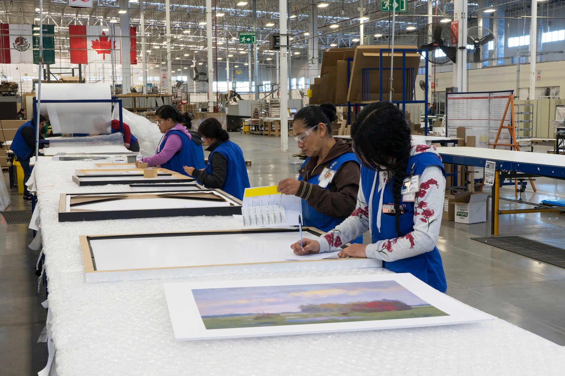 Wholesale team reviewing art orders and production sheets at Art Brand Studios facility – Exclusive Wholesale Benefits for Retailers.