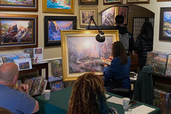 Retail partners viewing new art releases at Art Brand Studios showcase – Member promotions and exclusive offers.