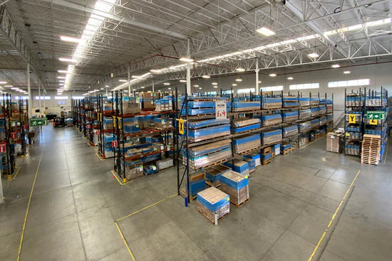 Wholesale art warehouse with organized shelves of canvas prints – Art Brand Studios distribution center.