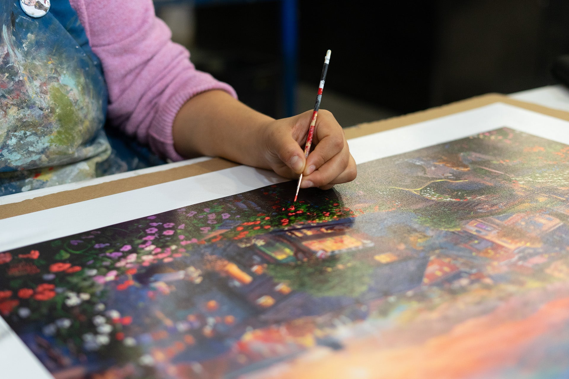 Close-up of artist painting fine art print details at Art Brand Studios – Unlock access to legendary artists