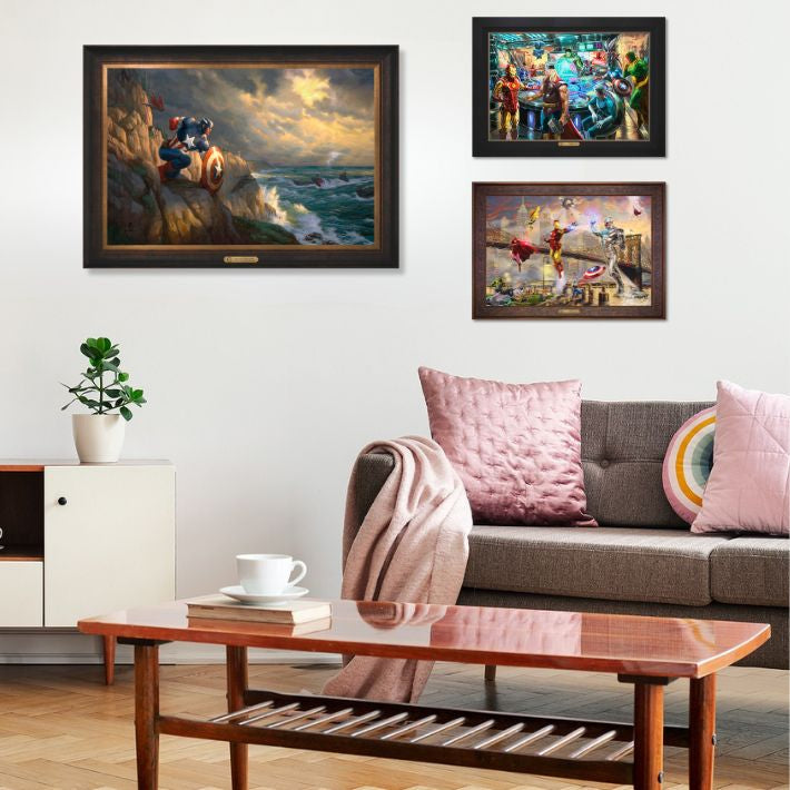 Living room with three paintings on the wall, showcasing Marvel scenes, wrapped in wooden frames.