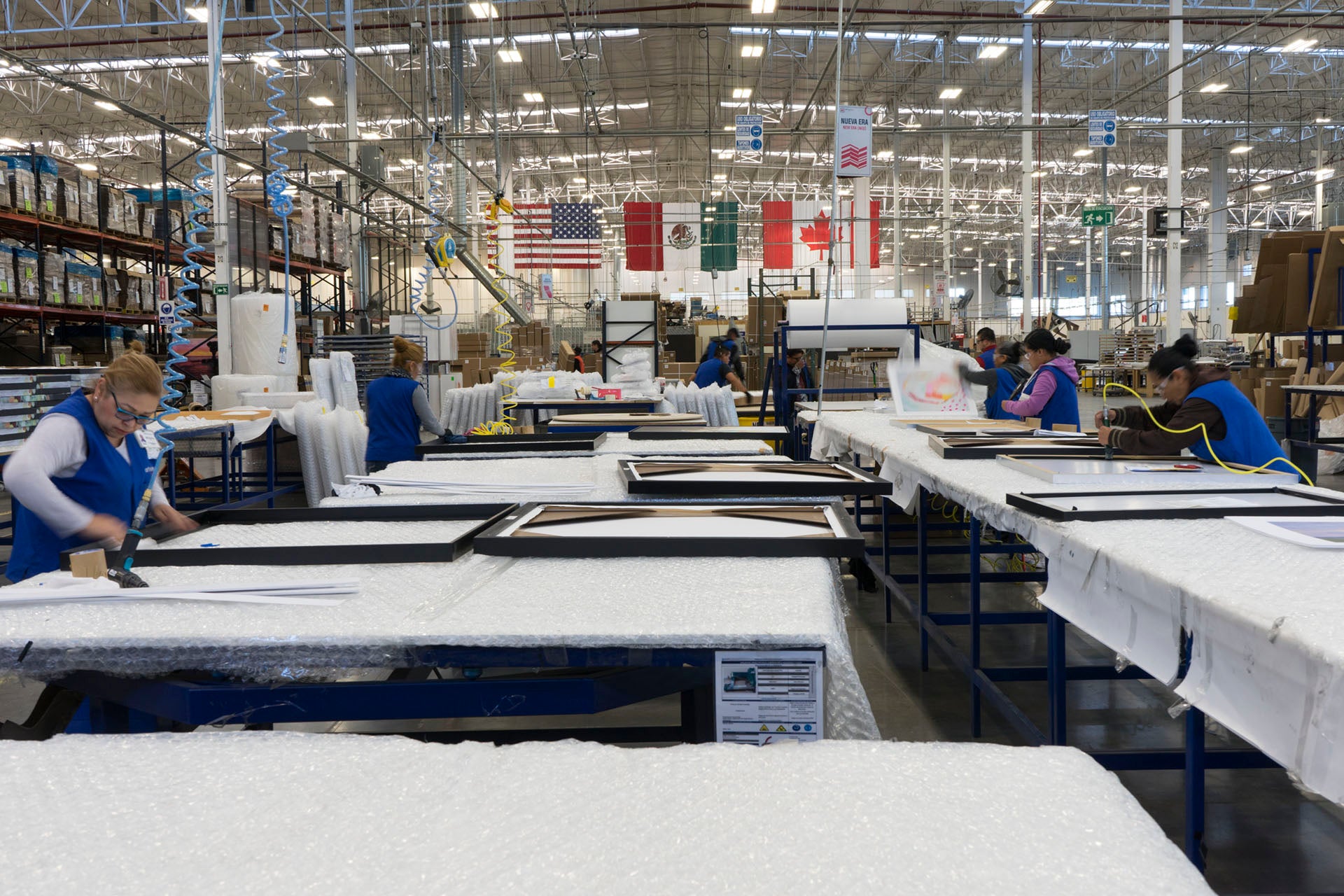 Team members stretching and framing canvas artwork at Art Brand Studios wholesale production facility – Art Brand Studios Wholesale Program