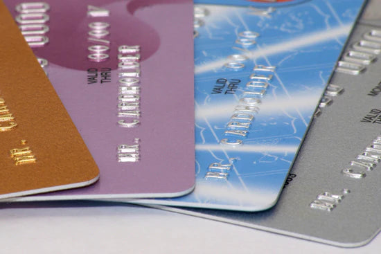 An array of colored credit cards lying flat symbolizes discounts for retailers – Art Brand Studios retail support. 